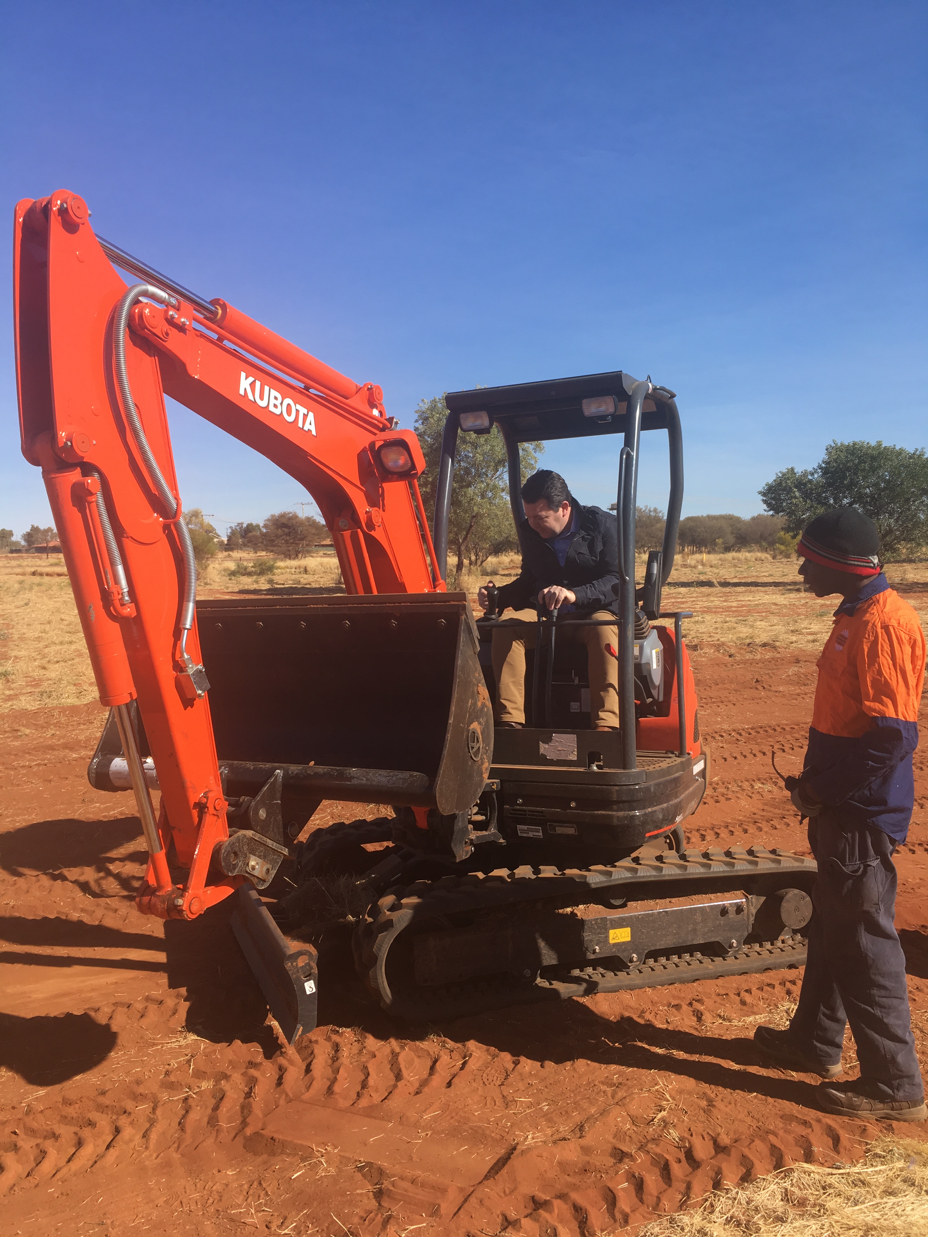\x3cp\x3eCommittee member Senator Dean Smith learning how to operate a mini-excavator used by Community Development Program participants at Papunya, NT, 29 August 2017.\x3c/p\x3e