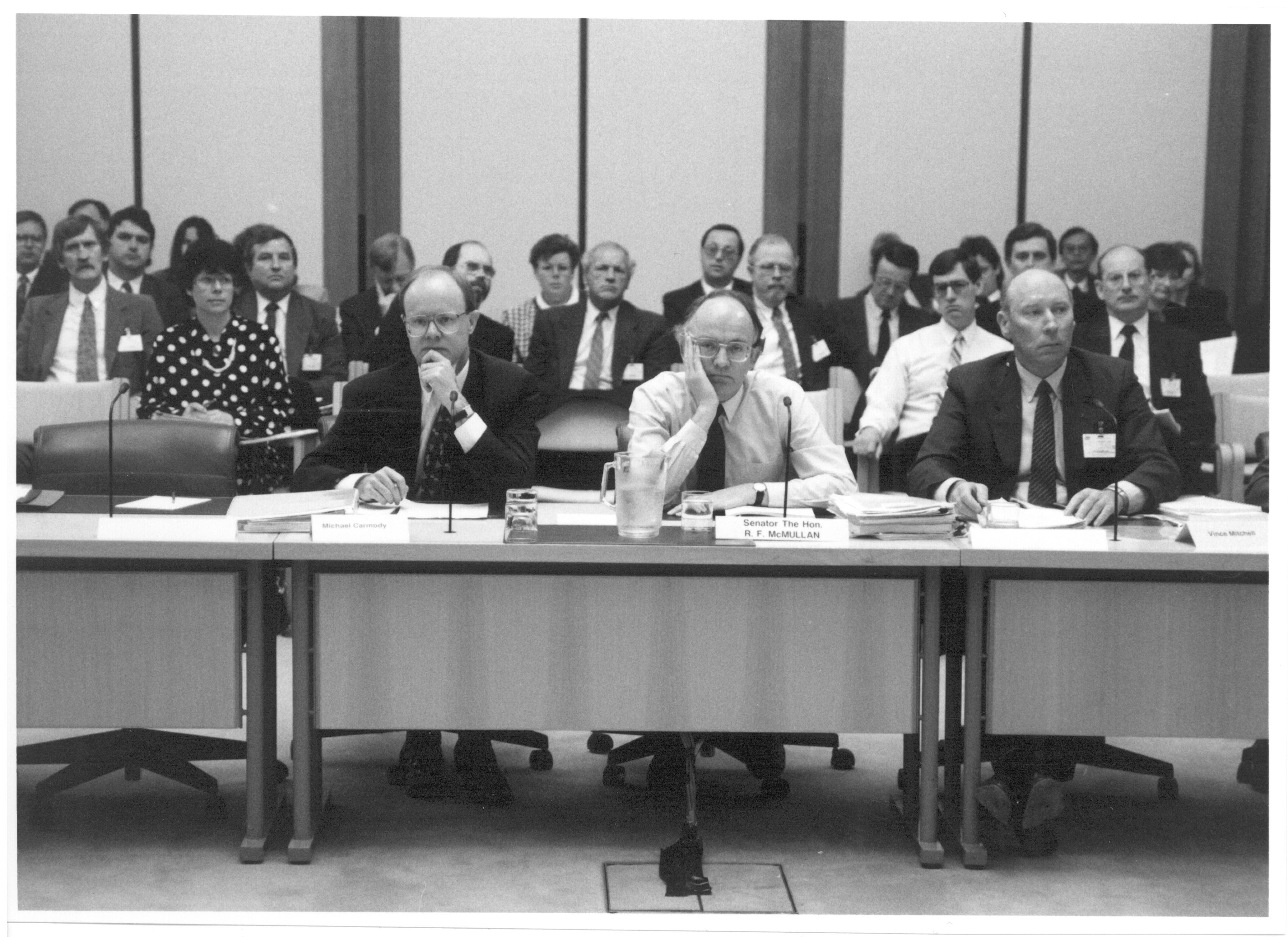 \x3cp\x3eSenator the Hon Bob McMullan, Parliamentary Secretary to the Treasurer, appearing with officers from the Australian Taxation Office at supplementary budget estimates hearing, 11 October 1991. Seated L-R: Witnesses Michael Carmody [Second Commissioner of Taxation], Senator Bob McMullan [Parliamentary Secretary to the Treasurer] and Vince Mitchell [First Assistant Commissioner, Taxpayer Audit].\x3c/p\x3e