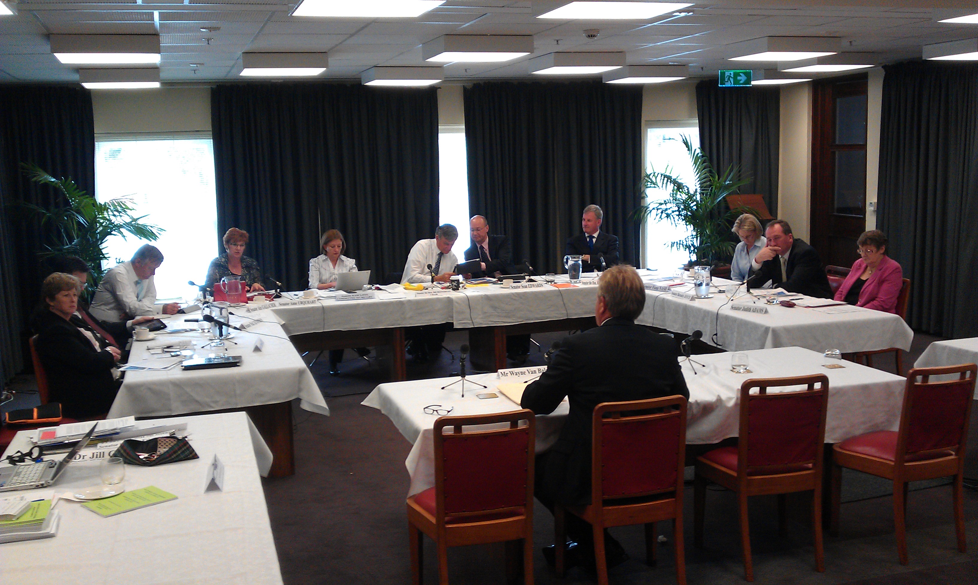 \x3cp\x3eCommittee hearing, Private Members Dining Room, Old Parliament House, Canberra, 16 November 2011. L-R: Senators Christine Milne, Nick Xenophon (obscured), Alex Gallacher and Anne Urquhart, Jeanette Radcliffe [Committee Secretary], Senators Bill Heffernan [Chair], Sean Edwards, Richard Colbeck, Fiona Nash, Barbaby Joyce and Judith Adams. Foreground: Wayne Van Balen [witness].\x3c/p\x3e