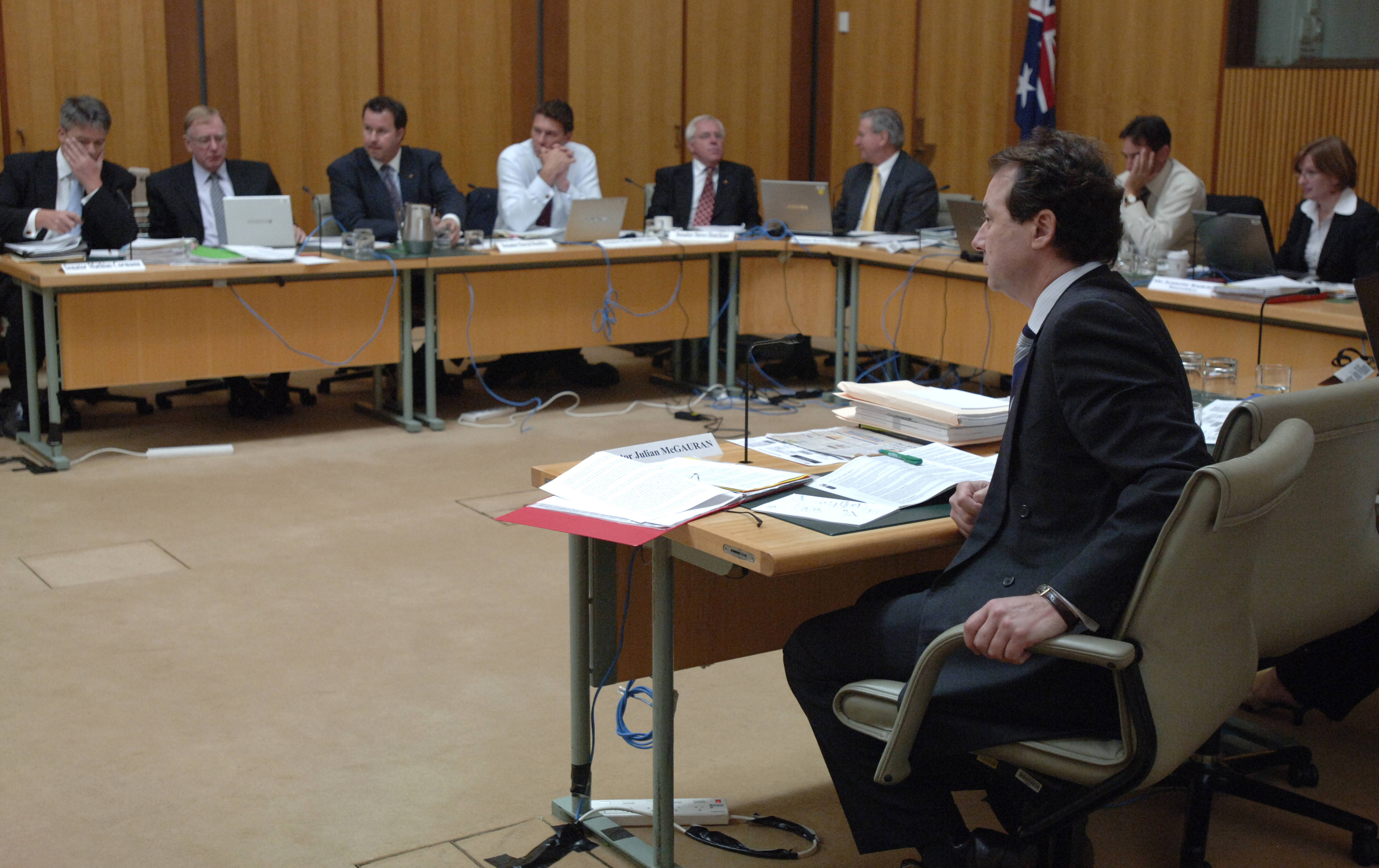\x3cp\x3eMembers of the Standing Committee on Rural and Regional Affairs and Transport at an additional estimates hearing, 24 February 2009. L-R: Senators Mathias Cormann, Ian Macdonald, David Bushby, Cory Bernardi, Steve Hutchins, Kerry O\'Brien and Glenn Sterle [Chair], and Jeanette Radcliffe [Secretary]. Senator Julian McGauran in foreground. DPS Auspic.\x3c/p\x3e